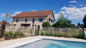 A two-story house with a swimming pool in the foreground.