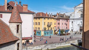 A historic town with a canal, stone buildings, and a clear blue sky.