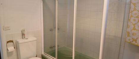 Un baño con inodoro, cabina de ducha y bañera.