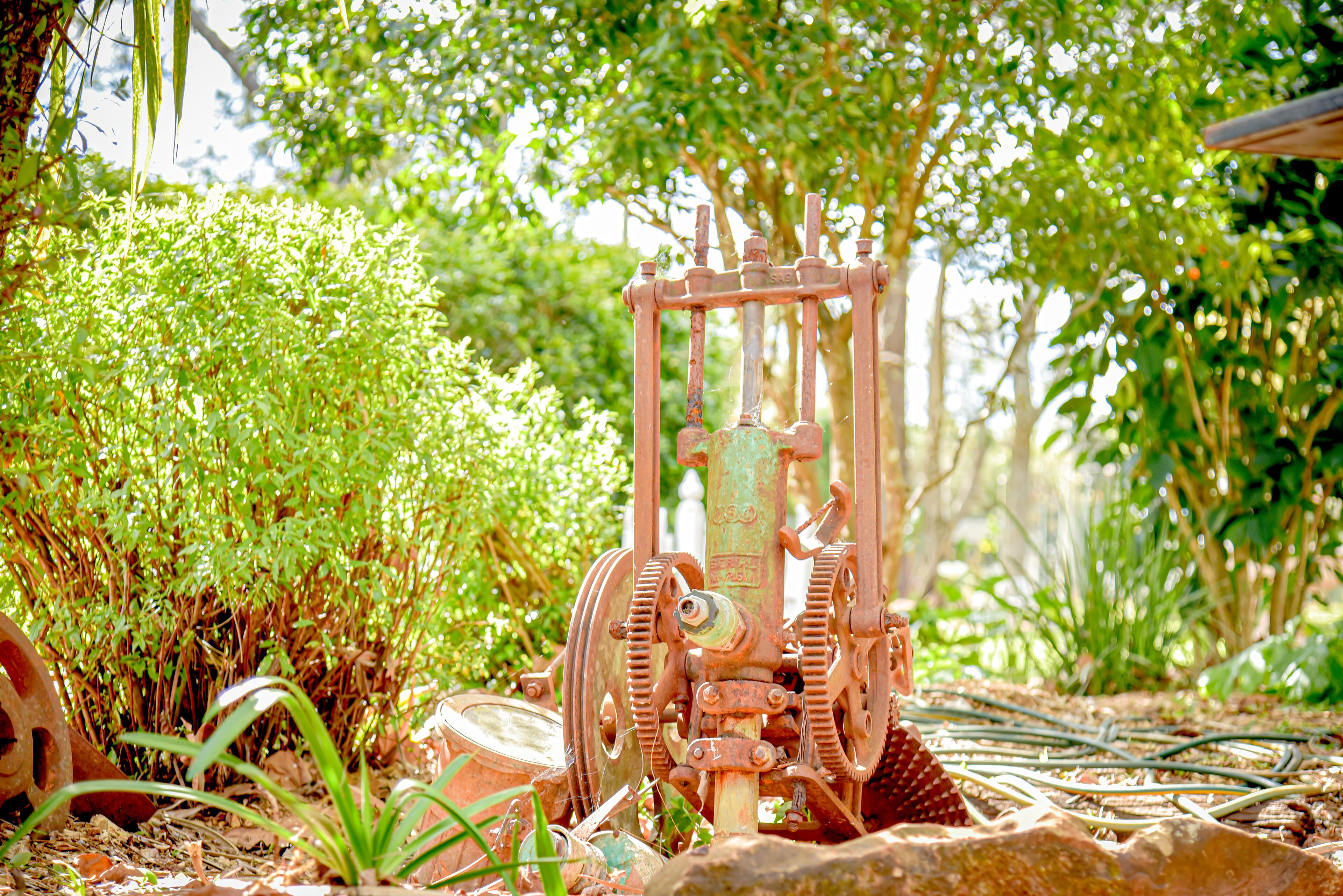 Een oud, verroest mechanisch apparaat in een tuin.