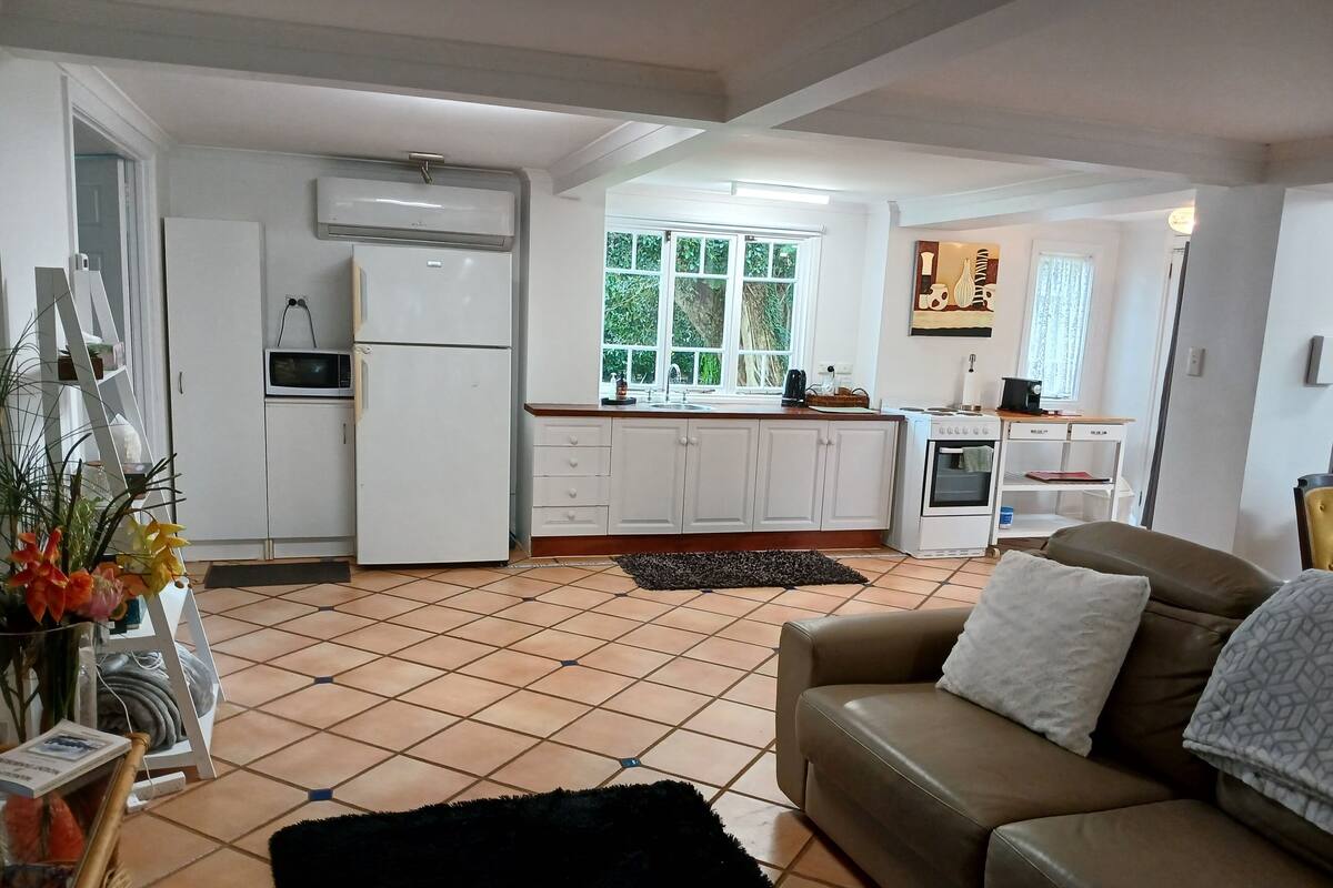 A compact living space with a kitchenette, a sofa, and a dining area.