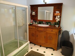 A bathroom with a shower, a sink, and a vanity with a mirror. - Memory Lane Accommodation (Tamborine Mountain)