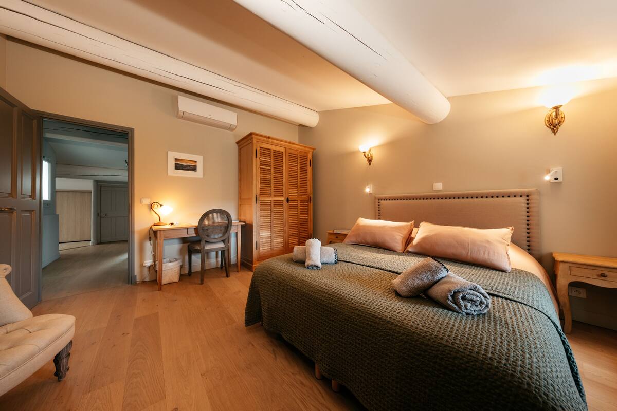 Quarto com cama, escrivaninha, cadeira, guarda-roupa e mesa de cabeceira.