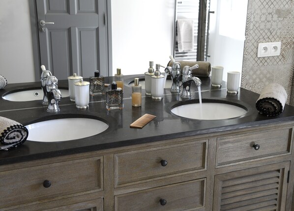 A bathroom with two sinks, a mirror, and various toiletries. - Domaine Perréal (Gargas)