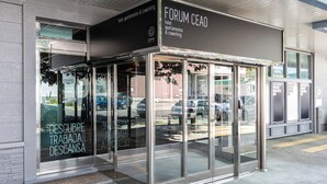 Ingresso moderno di un hotel con porte in vetro e insegna che indica la presenza di appartamenti e spazi di coworking.