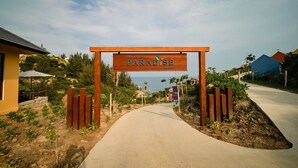 A pathway leading to a wooden sign that reads "Paradise Resort." -  Life Resort Quy Nhon (Cat Tien)