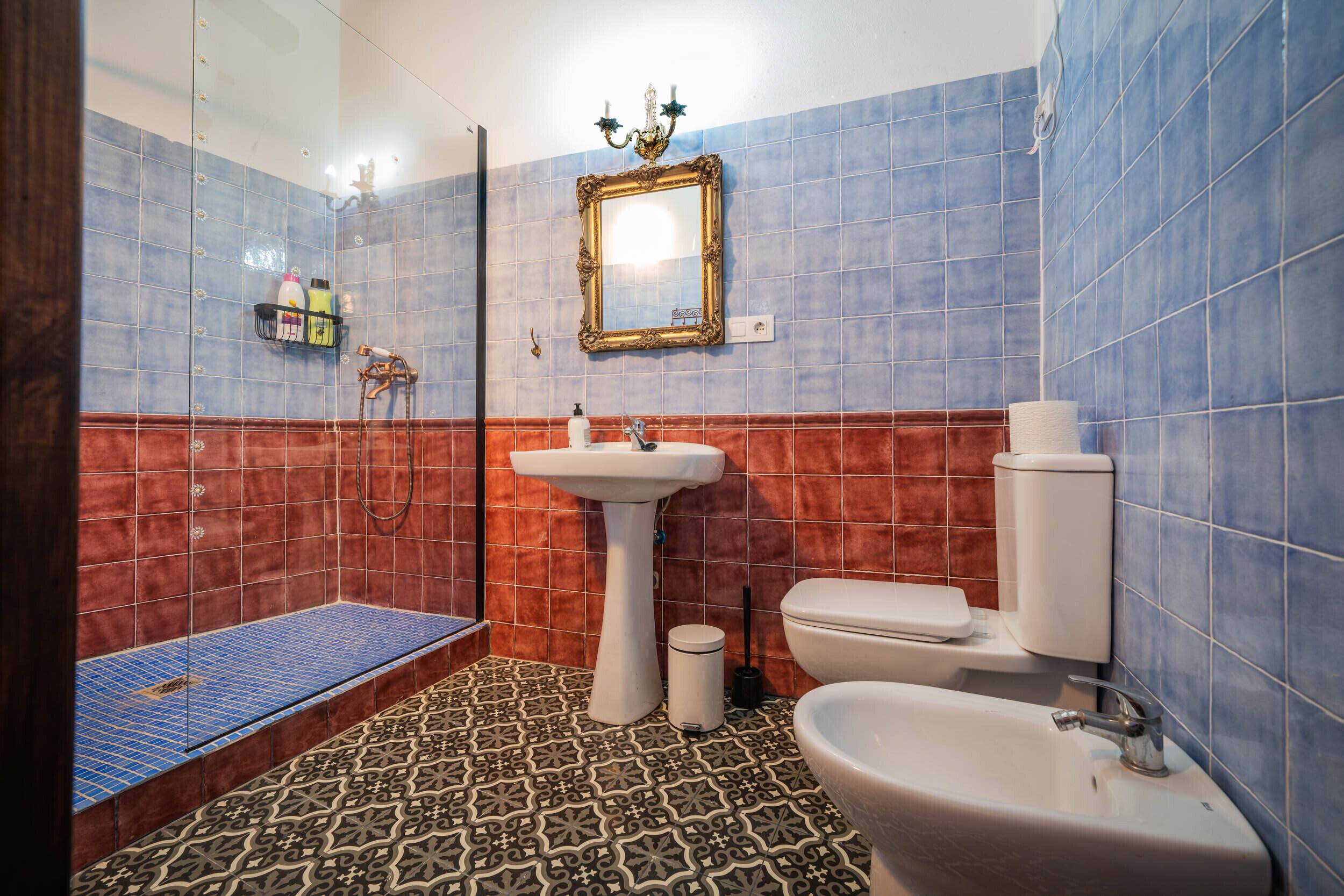 Une salle de bain équipée d’une douche, d’un lavabo, de toilettes et d’un miroir.