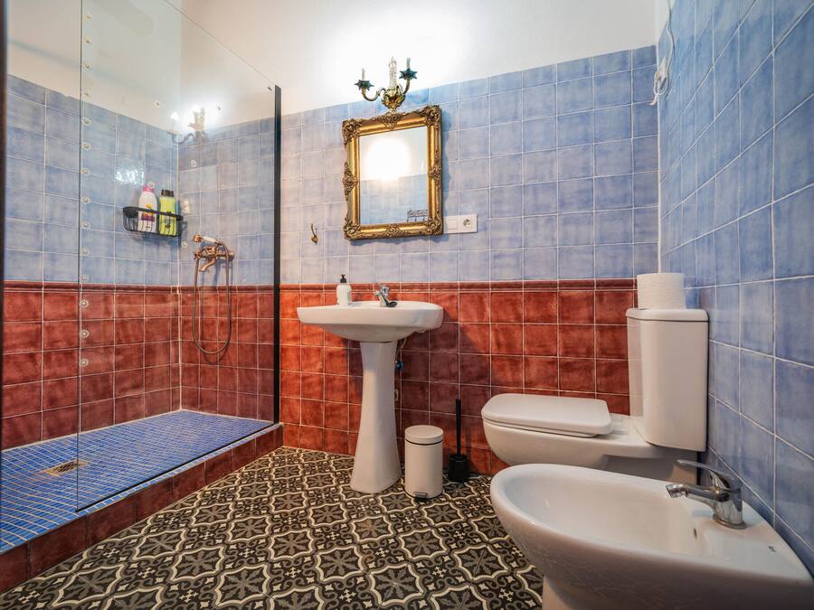 Une salle de bain équipée d’une douche, d’un lavabo, de toilettes et d’un miroir.