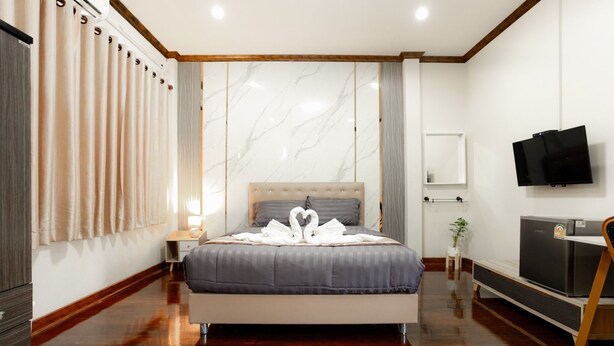 A hotel room with a bed, a TV, a desk, and a wardrobe. - 2B Cozy Hostel (Trang)