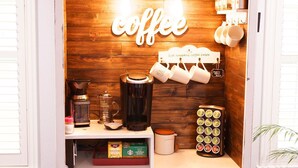 Una estación de café con un fondo de madera, una máquina de café y diferentes tazas y recipientes para café.