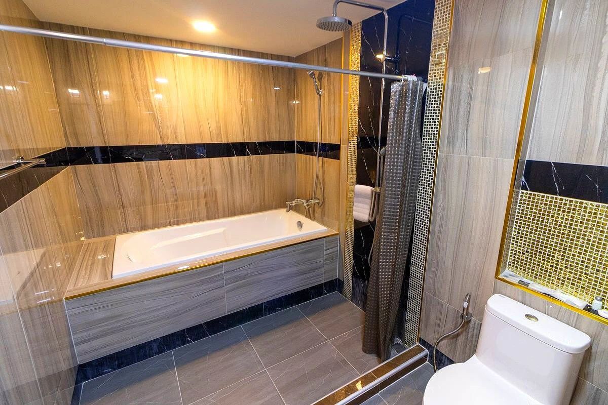 Une salle de bain moderne avec une baignoire sur pieds, un espace douche et des toilettes.