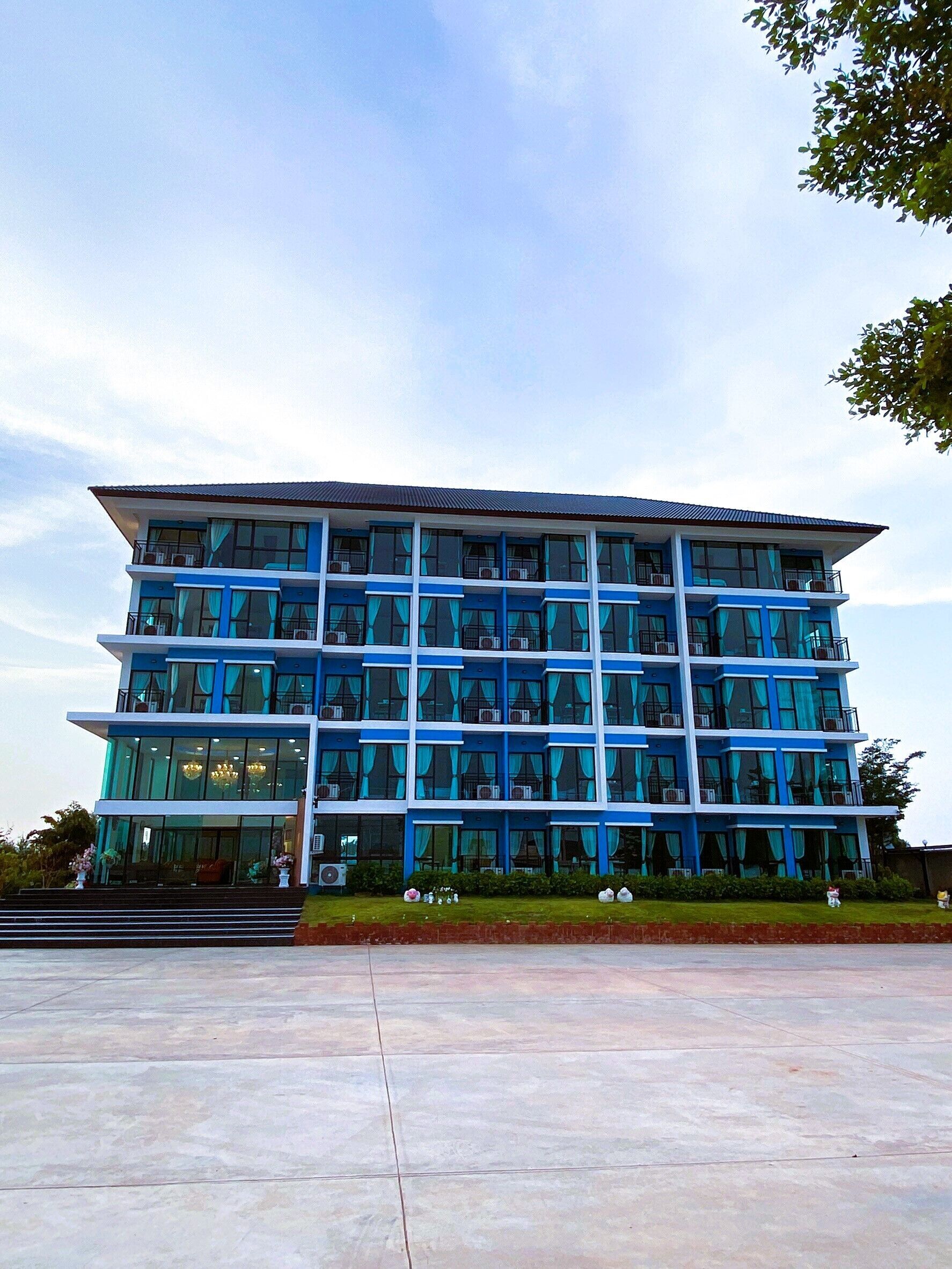 A multi-story hotel with a modern design, featuring large windows and balconies.