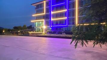 Un edificio moderno con fachada de vidrio y líneas de neón iluminadas.