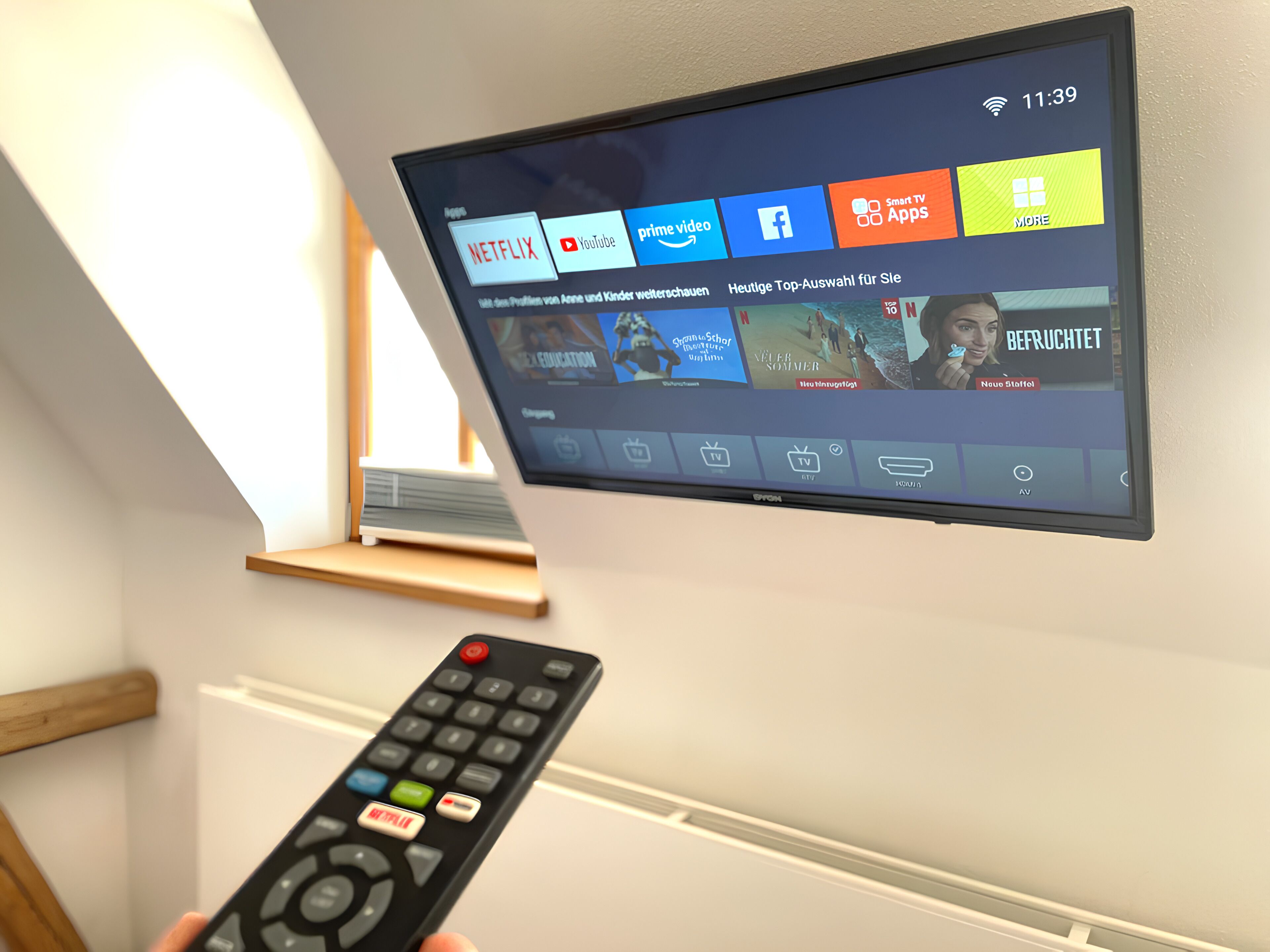 A television mounted on a wall displaying various streaming services.