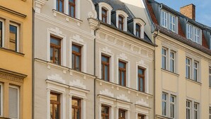 A row of classic European-style buildings with uniform window designs and a consistent architectural style. - Central | Cozy | Digitaler Check-in (Hof)