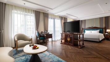 A hotel room with a bed, a TV, a desk, and a chair.