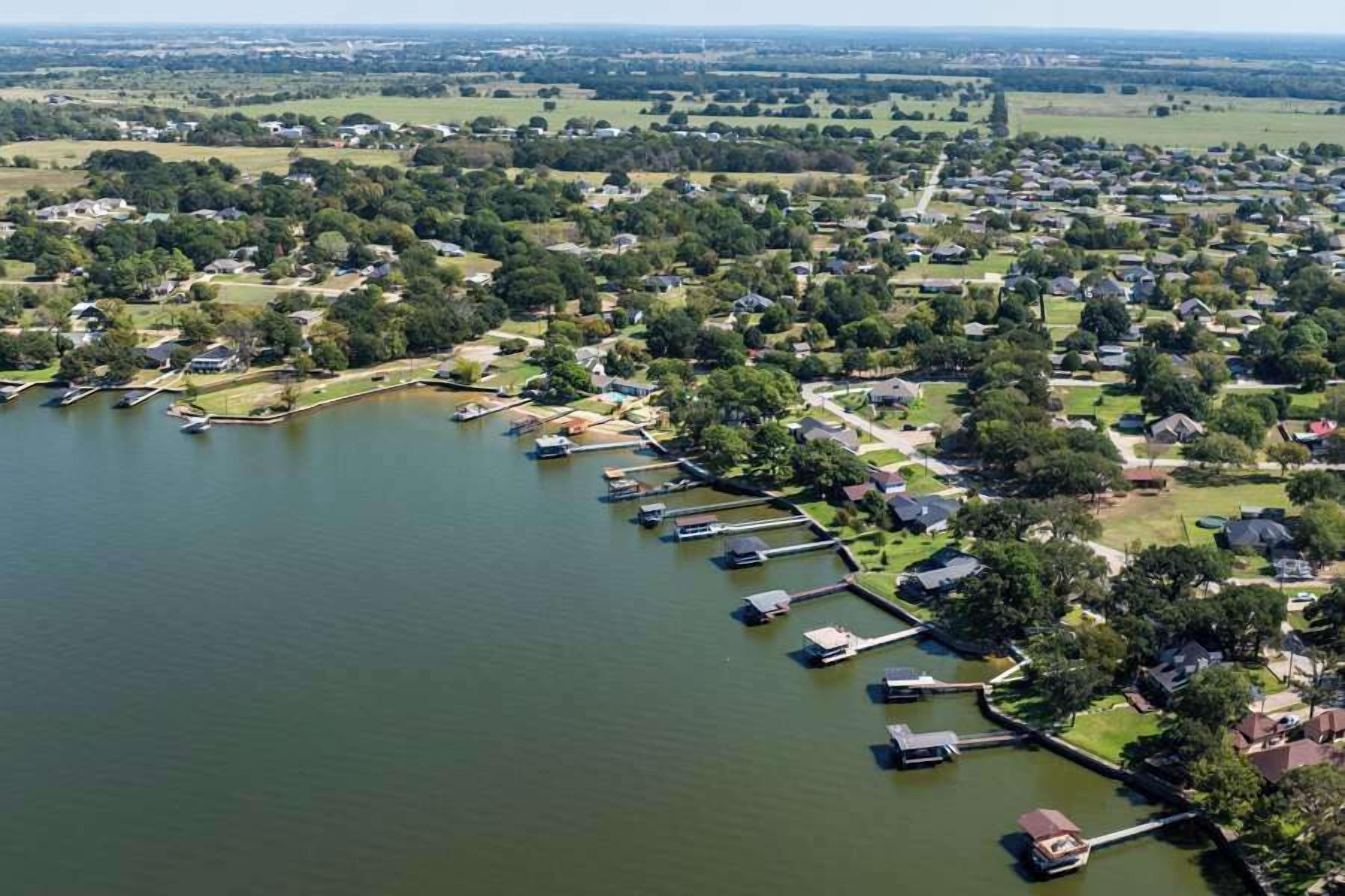 A residential area with houses, a lake, and docks.