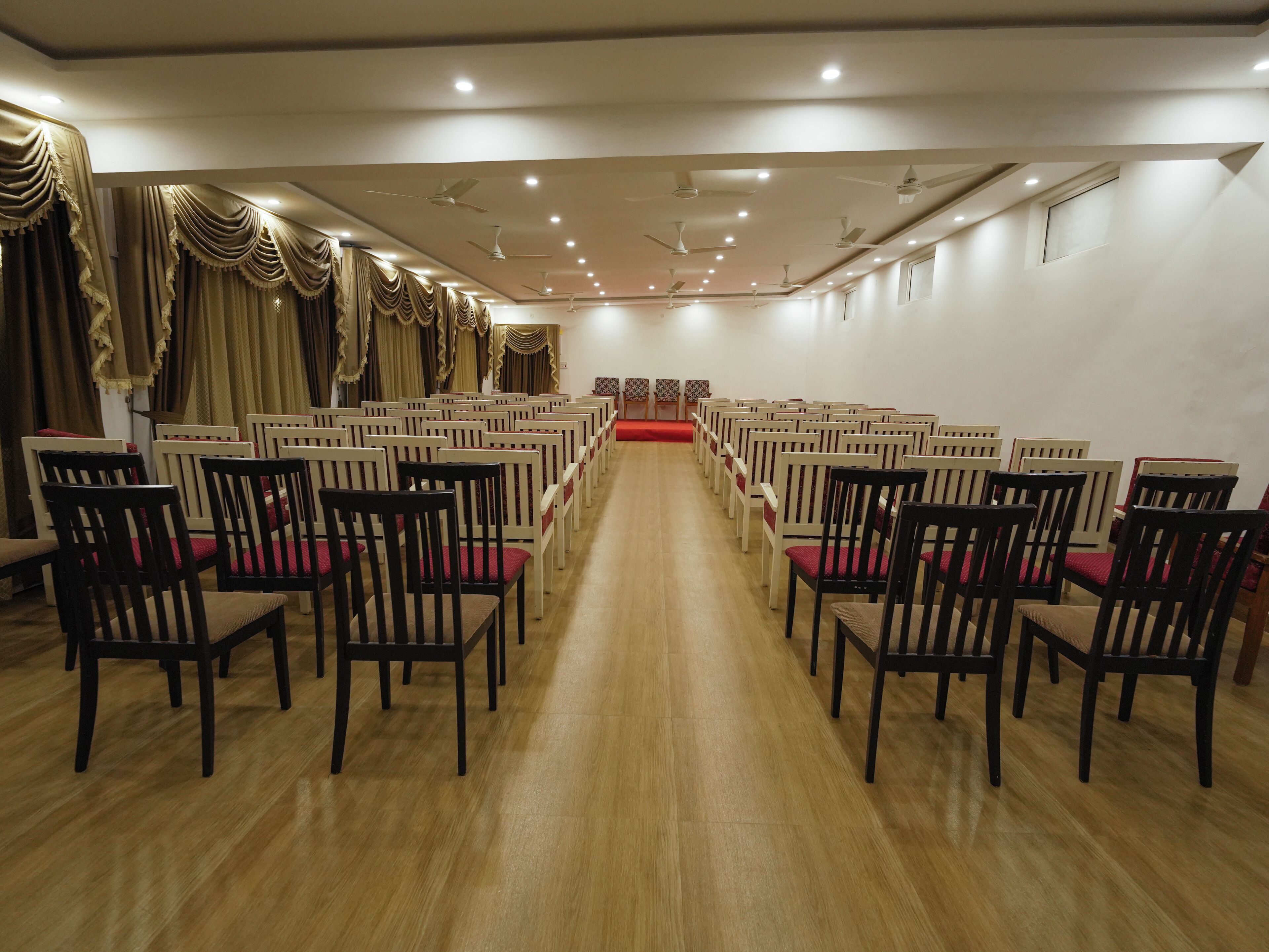 Un salón de conferencias con hileras de sillas orientadas hacia un escenario.