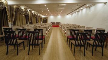 Un salón de conferencias con hileras de sillas orientadas hacia un escenario.
