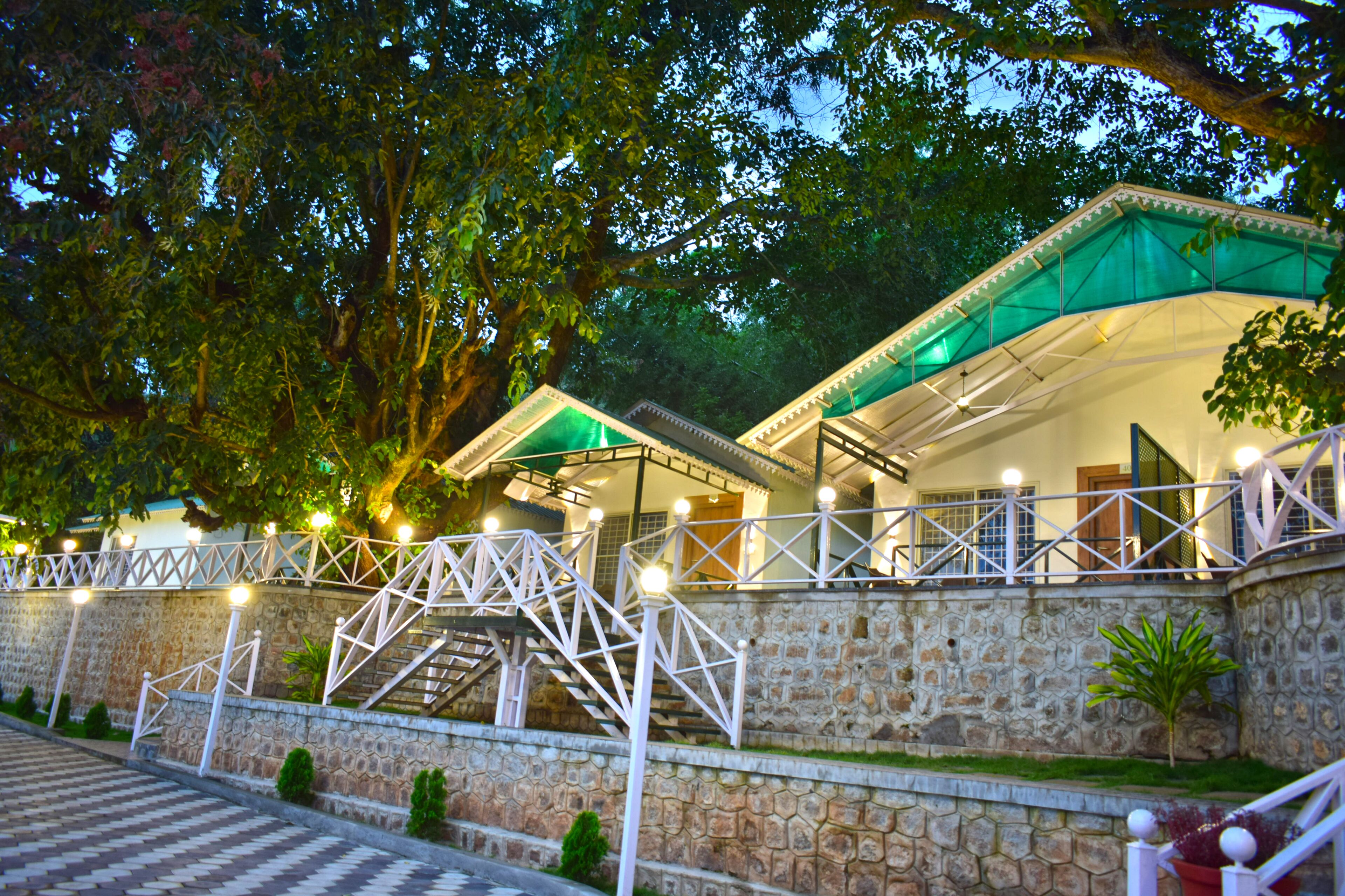 A stone-walled building with a staircase and a covered area with lights.