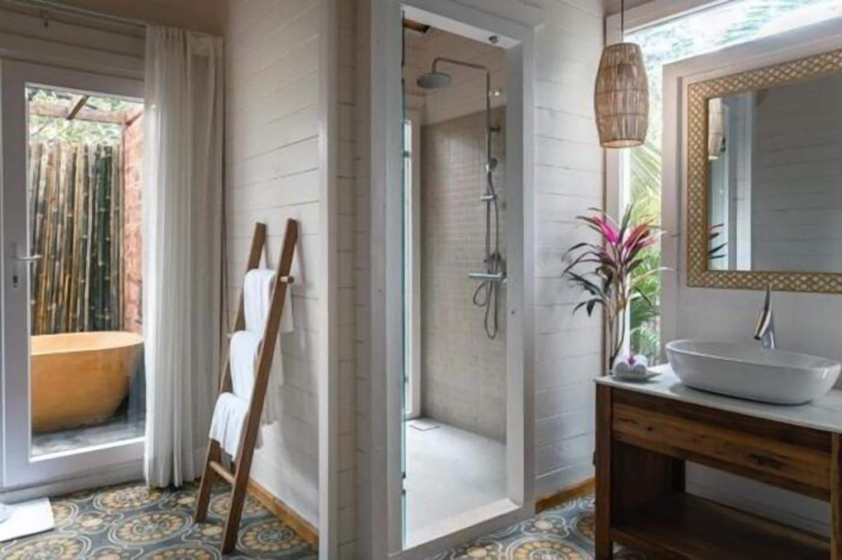 A bathroom with a large bathtub, a shower, a wooden vanity, and a large mirror.
