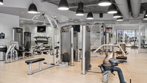 Een moderne sportschool met diverse fitnessapparaten, waaronder krachttrainers en cardioapparaten.
