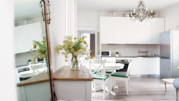 A modern kitchen with white cabinets, a wooden countertop, and a chandelier. - Glamour (Como)