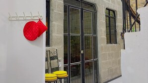 A room with a stone wall, a large window, and a yellow chair.