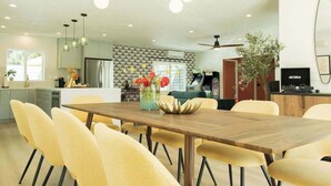 Una cucina moderna con zona pranzo, frigorifero e ventilatore a soffitto.