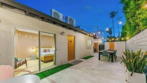 A modern hotel room with a sliding glass door, a bed, a small table, and a chair. - Desert Modern Retreat in Vibrant Palm Springs (Palm Springs)