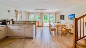 Une cuisine spacieuse avec un îlot central, une table à manger en bois et des chaises.