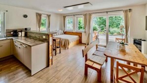Une chambre d’hôtel compacte comprenant un coin cuisine, un espace repas et un lit.