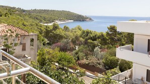 A coastal view with a beach, greenery, and buildings. - Oelia Rooms & Apartments  (Aegina)