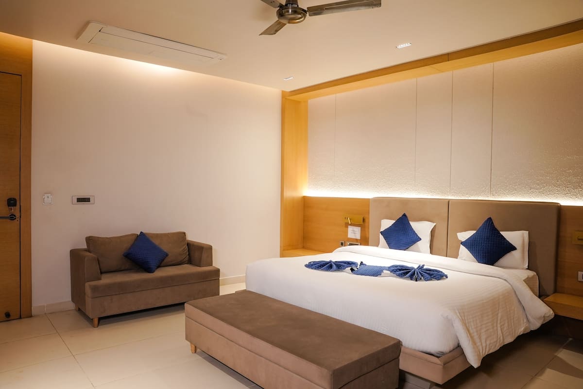 Une chambre d’hôtel moderne, équipée d’un lit, d’un canapé et d’un banc.