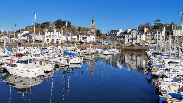A marina with boats docked, a prominent tower, and buildings along the waterfront. - La Récréation - 1 bedroom apartment La Marelle - Covered outdoor swimming pool (Châtelaudren-Plouagat)