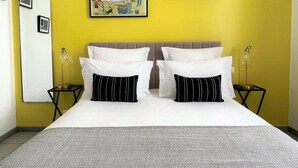 A hotel room with a bed, two bedside tables, a nightstand, a mirror, and two framed pictures on the wall. - La Récréation - 1 bedroom apartment La Marelle - Covered outdoor swimming pool (Châtelaudren-Plouagat)