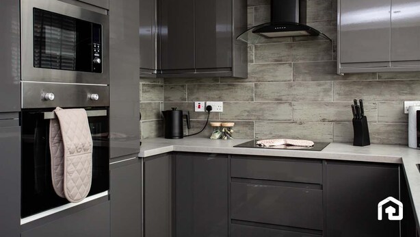 A modern kitchen with stainless steel appliances, a built-in oven, and a countertop with a kettle and knives. - Free Parking | 5 Min to Metro Centre | Modern House (Newcastle Upon Tyne)