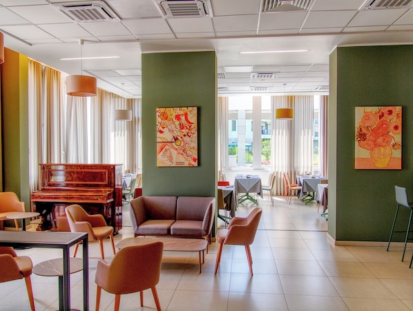 A spacious room with a piano, comfortable seating, and large windows.