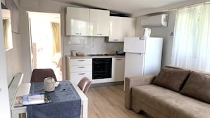 A compact living space with a kitchenette, dining area, and a sofa. - Lovely 1 Bedroom Apartment (Kastela)