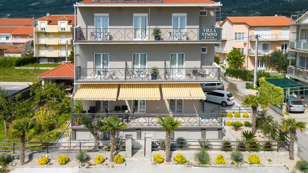 A multi-story building with balconies, solar panels, and a yellow awning. - Double bed Room With Private Bathroom and Balcony (Kastela)