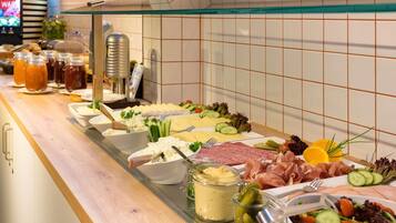 Ein reichhaltiges Buffet mit Käse, Fleisch und Salaten.