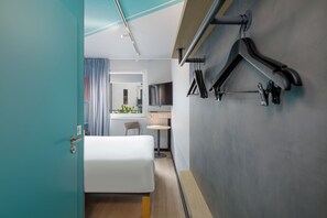 Une chambre d’hôtel moderne équipée d’un lit, d’un bureau et d’un coin salon.