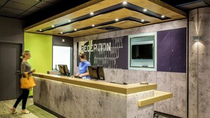 Un mostrador de recepción con encimera de madera y un amplio ventanal.