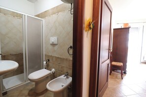 Un baño con inodoro, bidé y lavamanos.