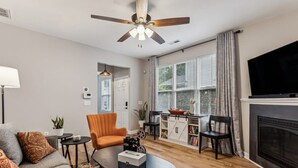 Una sala de estar con sofá, sillón, mesa de centro y chimenea.
