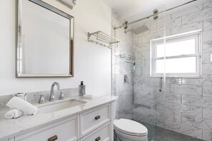A modern bathroom with a marble sink, a large mirror, a glass shower enclosure, and a toilet. - Delray Oasis: Pool, Gazebo & Beach Access (Delray Beach)