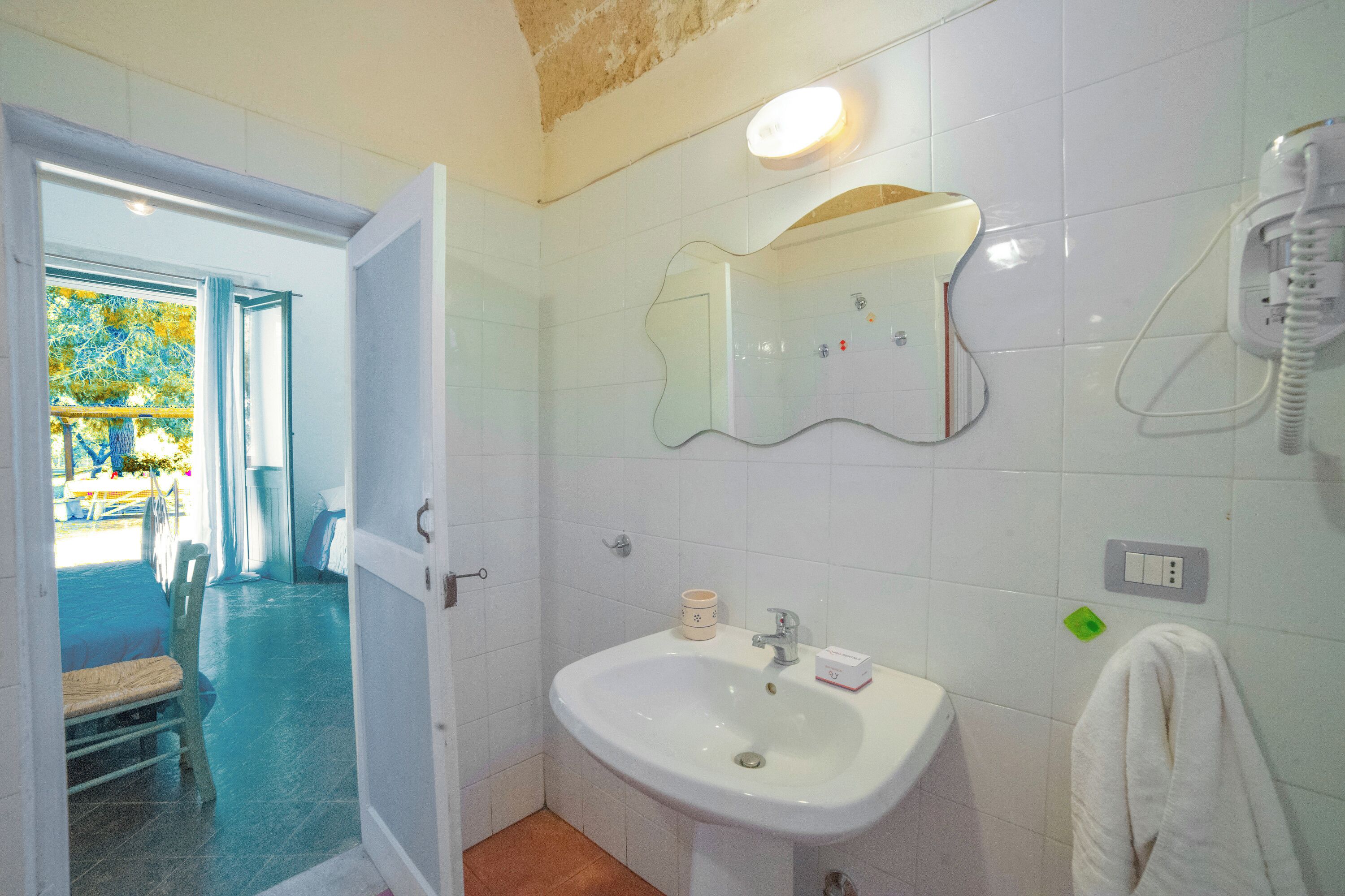 A bathroom with a sink, mirror, and towel rack.