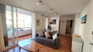 Ein modernes Wohnzimmer mit grauem Sofa, einem Holztisch und einem weißen Schrank.