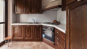 Een keuken met houten kastjes, een fornuis en een spoelbak.