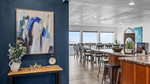 A modern kitchen with a bar area, a large abstract painting, and a clock on the wall. - Azul Jewel Estate, Game Room, Movie Room & Beach (Depoe Bay)